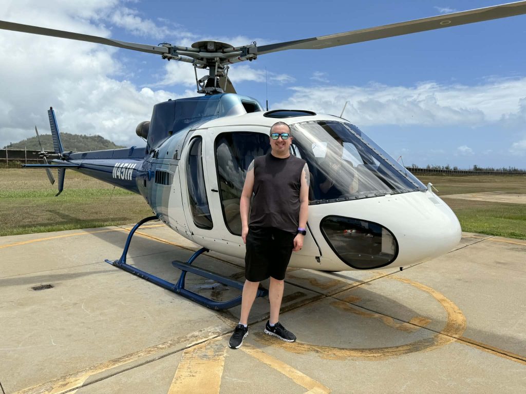 Esten stands in front of a parked helicopter